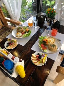 uma mesa de madeira com pratos de comida em โรงแรมแสนดีเพลส เมาเท่นวิว จอมทอง em Chom Thong