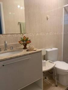 a bathroom with a sink and a toilet and a mirror at Sobrado Charmoso e Aconchegante / Santa Felicidade PR in Curitiba