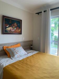 Un dormitorio con una cama con una manta amarilla. en Sobrado Charmoso e Aconchegante / Santa Felicidade PR en Curitiba