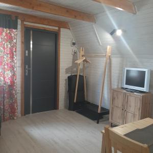 um quarto com uma porta e uma televisão numa bancada em domek good vibes B em Gnieżdżewo