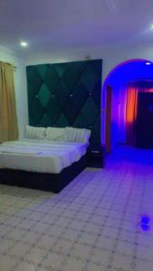 um quarto com uma cama num quarto com luzes roxas em Blue Moon Hotel Victoria Island em Lagos