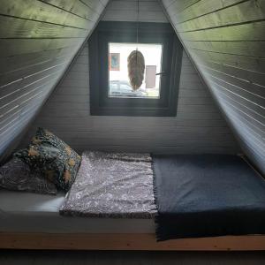 uma cama numa pequena casa com uma janela em domek good vibes B em Gnieżdżewo