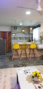 een keuken met gele stoelen en een aanrecht bij Tawali apartments in Mombasa