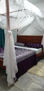 een slaapkamer met een hemelbed bij Tawali apartments in Mombasa