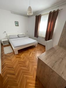 1 dormitorio con 1 cama y suelo de madera en House Magdic Plitvice, en Grabovac