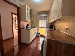 a kitchen with white cabinets and a wooden floor at Alquilaencanarias Caletillas Vista al Mar in Candelaria +12 photos