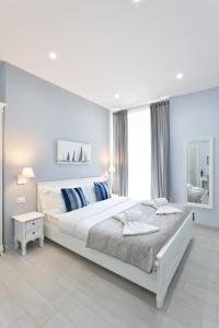 a white bedroom with a large bed and a window at Colosseo House in Rome