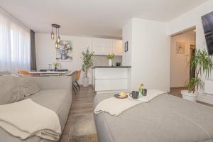 a living room with a couch and a kitchen at Apartman Holiday in Šibenik