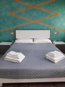 - une chambre avec un lit et des serviettes dans l'établissement Rivad’Elsa, à Baone