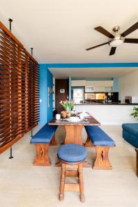 uma sala de estar com uma mesa e bancos azuis em Heart of Santa Marta / Designerloft / Rooftop Pool em Santa Marta