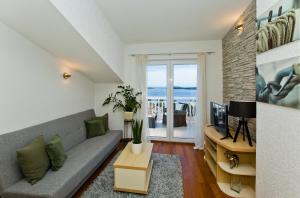 uma sala de estar com um sofá e uma TV em Apartment LUCE em Hvar