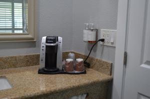Fairview Inn & Suites في هيلدسبورغ: آلة صنع القهوة على منضدة في الغرفة