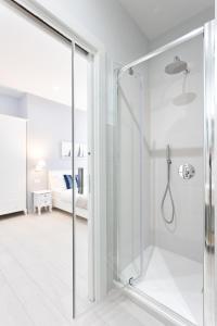 a glass shower in a bathroom with a bedroom at Colosseo House in Rome