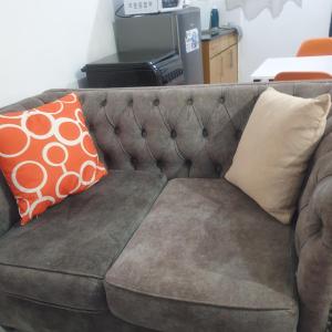 Un sofá marrón con dos almohadas. en Racecourse one bed apartment ngong Road, en Nairobi