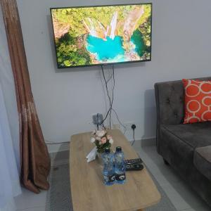 Sala de estar con mesa de centro y 2 botellas de agua en Racecourse one bed apartment ngong Road, en Nairobi