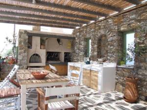 a kitchen with a table and a stone wall at Villa Irilia, Private Pool with Unrestricted Sea View in Fanari