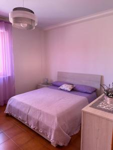 a bedroom with a large bed with purple sheets at Casa Vacanze Diva in Rosignano Solvay