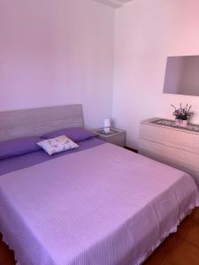 a bedroom with a purple bed and a night stand at Casa Vacanze Diva in Rosignano Solvay