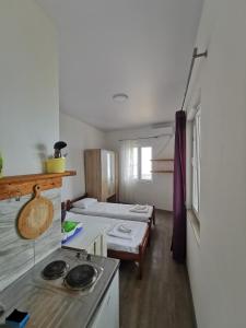 um quarto com 2 camas e uma cozinha com fogão em High Hostel em Budva