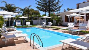 a swimming pool with lounge chairs and umbrellas at Villa Blanche Dimora Di Charme in Marsala