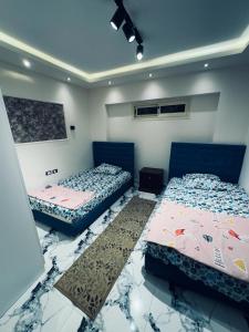 2 Betten in einem Zimmer mit Marmorböden in der Unterkunft بورتو السخنة in Ain Suchna