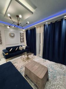 ein Wohnzimmer mit blauen Vorhängen und einem Sofa in der Unterkunft بورتو السخنة in Ain Suchna