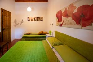 two beds in a room with green sheets at La Virgy per Noto with share swimming pool with woderful seaview in Avola
