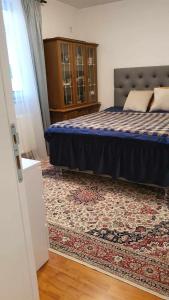 1 dormitorio con cama y alfombra en Kuca, en Sarajevo