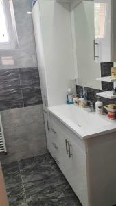 y baño blanco con lavabo y ducha. en Kuca en Sarajevo
