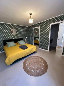 ein Schlafzimmer mit einem gelben Bett und einem Spiegel in der Unterkunft A Eze , Bas de villa piscine près de Monaco in Èze