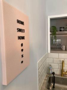 a bathroom with a sign that says home sweet home at Rustic Top Floor West End Pad With Balcony, Parking next to Byers Road, Aston Lane, Glasgow Uni in Glasgow