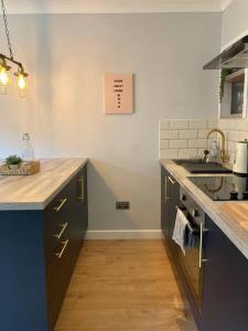 a kitchen with a sink and a counter top at Rustic Top Floor West End Pad With Balcony, Parking next to Byers Road, Aston Lane, Glasgow Uni in Glasgow