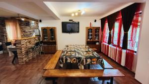 un soggiorno con tavolo, TV e camino di La Izvor Lepsa a Lepşa