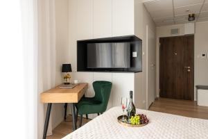 a small room with a table and a green chair at Luxury Design Apartments - Warsaw Tower Bliska Wola in Warsaw