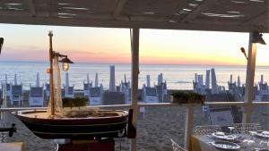 a restaurant with a boat on the beach at Villa Blanche Dimora Di Charme in Marsala