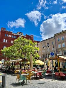 a group of tables and chairs with umbrellas and buildings at Cedar Inn Budapest - Palace District in Budapest