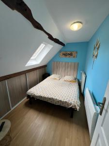 a bedroom with a bed in a room with blue walls at Petit F2 fonctionnel plein centre et proche gare in Bourges
