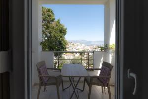 einen Tisch und Stühle auf einem Balkon mit Aussicht in der Unterkunft Korfes Apartments in Kamilari