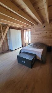 BrévandsにあるGîte au cœur du ddayの木造キャビン内のベッド1台が備わるベッドルーム1室を利用します。