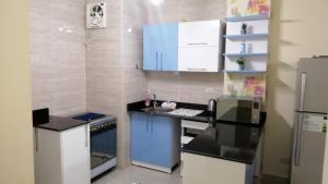 a small kitchen with blue cabinets and a refrigerator at Lasirena Mini Egypt in Ain Sokhna +20 photos