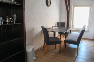 ein Esszimmer mit Tisch und Stühlen und einem Fenster in der Unterkunft Efeu 4 Pers in Röbel