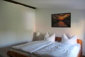 ein Schlafzimmer mit einem Bett mit weißen Laken und Kissen in der Unterkunft Efeu 4 Pers in Röbel
