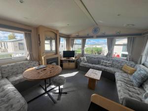 a living room with a couch and a table at Grouse 54, Scratby - California Cliffs, Parkdean, sleeps 6, pet friendly, bed linen, towels and Wi-Fi included in Scratby