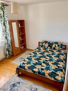 una camera da letto con un letto con un piumone floreale e uno specchio di Miejska oaza a Varsavia
