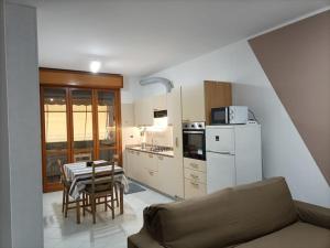een keuken met een bank en een tafel in een kamer bij Le Due Isole in Bologna