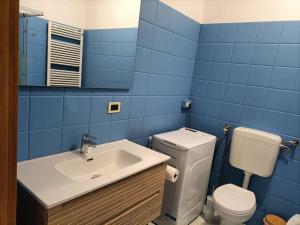 een blauwe badkamer met een toilet en een wastafel bij Le Due Isole in Bologna