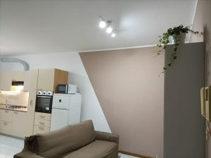een woonkamer met een stoel en een keuken bij Le Due Isole in Bologna