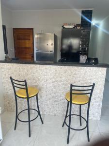 zwei Stühle vor einer Küchentheke in der Unterkunft Casa de praia Itanhaém Cibratel 2 concorrida in Itanhaém