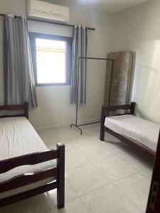 Zimmer mit 2 Etagenbetten und einem Fenster in der Unterkunft Casa de praia Itanhaém Cibratel 2 concorrida in Itanhaém