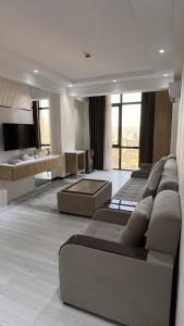 ein großes Wohnzimmer mit Sofas und einem TV in der Unterkunft Firdavsi Hotel in Duschanbe